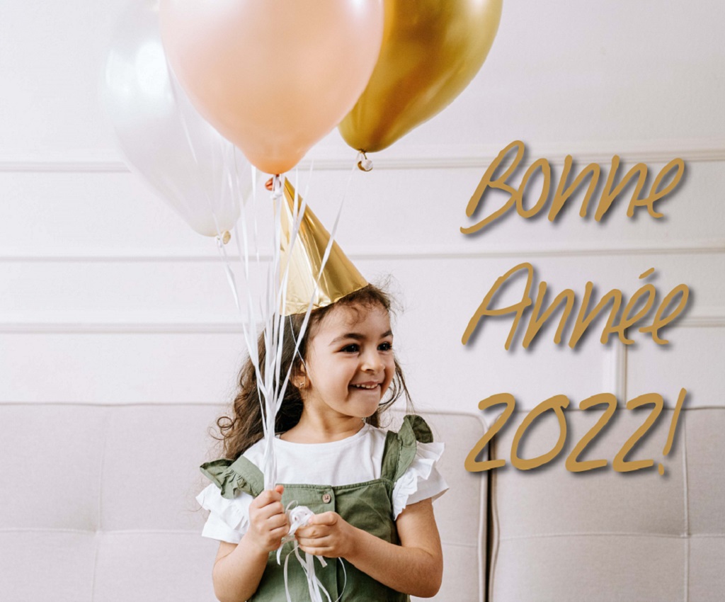 Une petite fille avec un chapeau de fête tenant des ballons. Texte : "Bonne année 2022 !". Logo de Lucie Care en bas de l'image